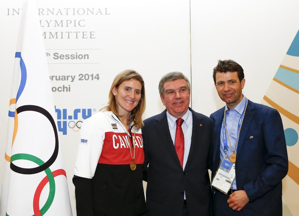 International Olympic Committee (IOC) President Bach pose with newly elected members of the IOC, Canada's Wickenheiser and Norway's Bjoerndalen, at the IOC session on the final day of the Sochi 2014 Olympic Winter Games in Sochi