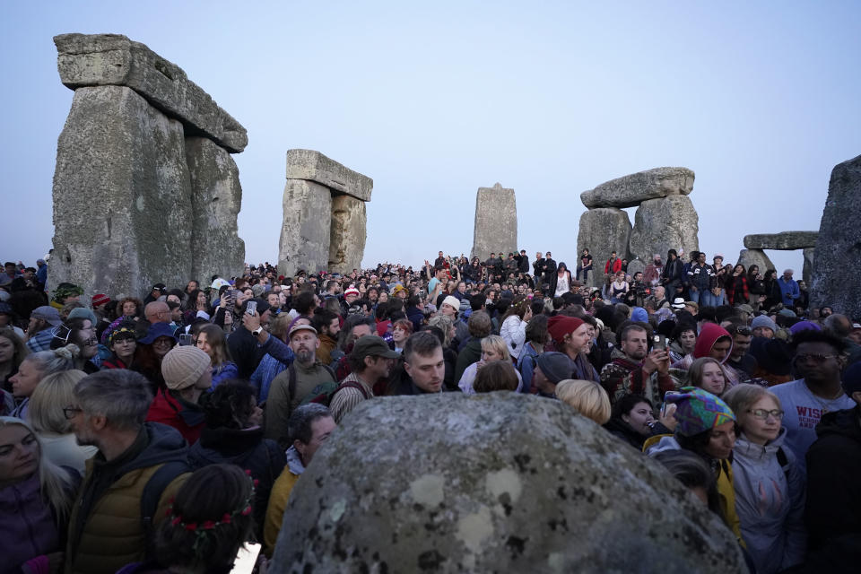 People gather during sunrise as they take part in the Summer Solstice at Stonehenge in Wiltshire, England Wednesday, June 21, 2023. (Andrew Matthews/PA via AP)