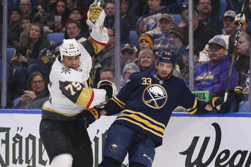 Buffalo Sabres defenseman Colin Miller (33) and Vegas Golden Knights forward Ryan Reaves (75) colllide behind the net during the second period of an NHL hockey game Tuesday, Jan. 14, 2020, in Buffalo, N.Y. (AP Photo/Jeffrey T. Barnes)