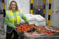 Rachel Ledwith from the charity 'The Felix Project' collects food at their storage hub in London, Wednesday, May 4, 2022. Across Britain, food banks and community food hubs that helped struggling families, older people and the homeless during the pandemic are now seeing soaring demand. The cost of food and fuel in the U.K. has risen sharply since late last year, with inflation reaching the highest level in 40 years. (AP Photo/Frank Augstein)