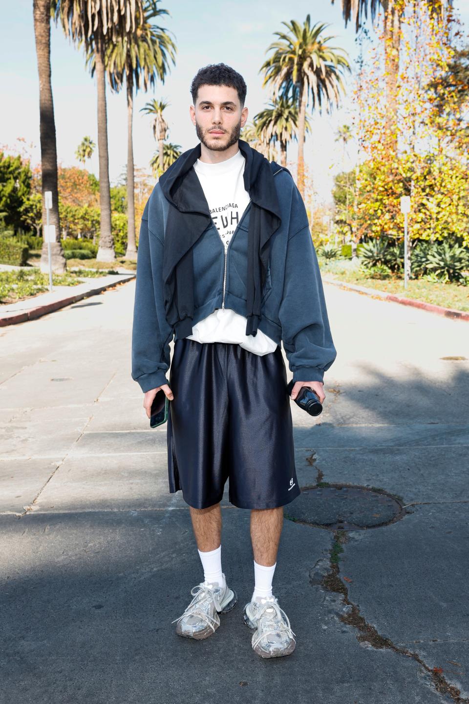 Fai Khadra at the Balenciaga show, holding a jet-black Erewhon juice.