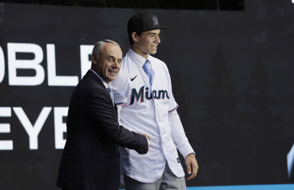 Noble Meyer, right, shakes hands with commissioner Rob Manfred as he is picked by the Chicago White Sox in baseball's amateur draft, Sunday, July 9, 2023, in Seattle. (AP Photo/John Froschauer)