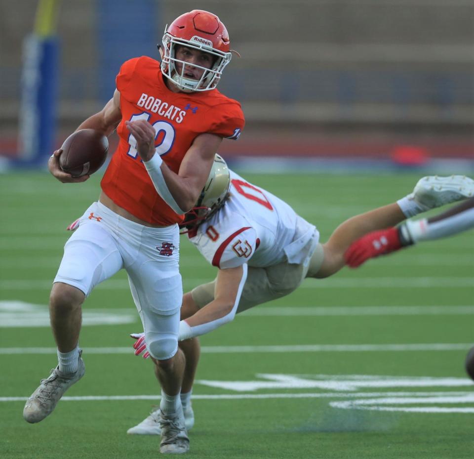 San Angelo Central High School quarterback Tyler Hill, left, eludes a Lubbock Coronado defender during a preseason scrimmage at San Angelo Stadium on Thursday, Aug. 18, 2022.