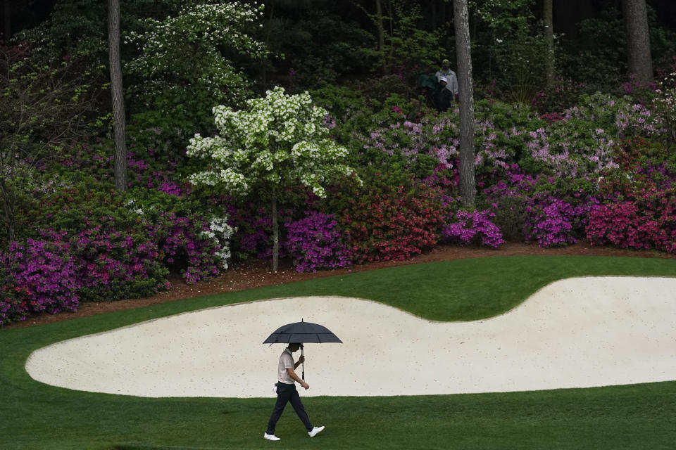 Justin Rose, of England, walks in the rain to the 13th green during the third round of the Masters golf tournament on Saturday, April 10, 2021, in Augusta, Ga. (AP Photo/Gregory Bull)