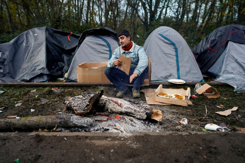 FILE PHOTO: A Kurdish migrant sits outside tents at a makeshift camp in Loon-Plage near Dunkirk, France,