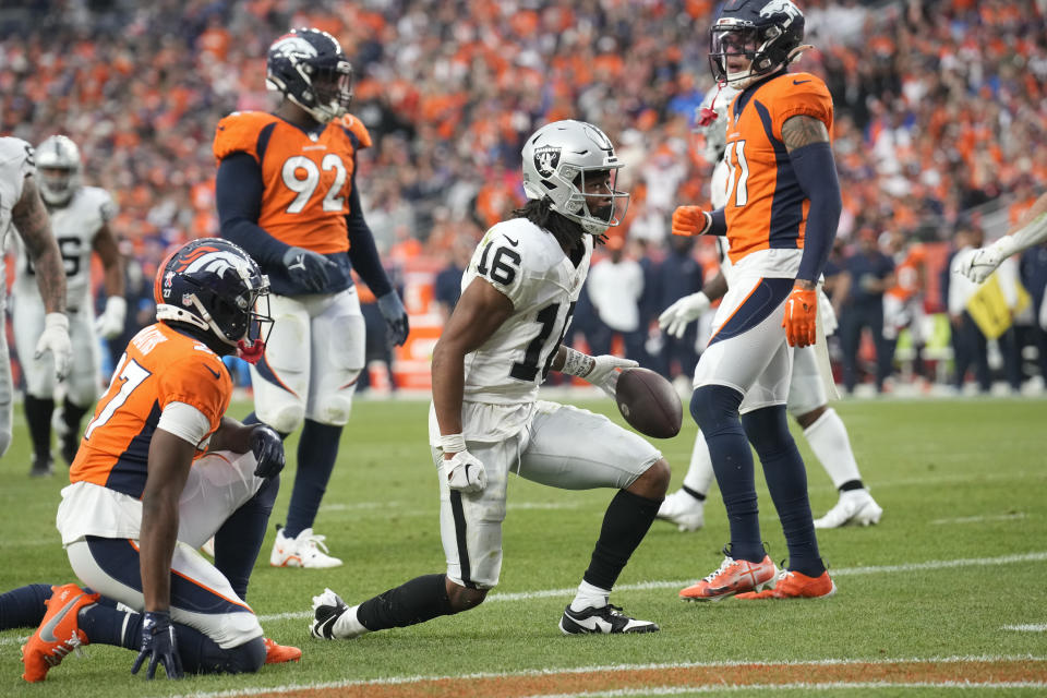 Las Vegas Raiders wide receiver Jakobi Meyers (16) holds the ball after making a touchdown catch beating Denver Broncos cornerback Damarri Mathis, left, during the second half of an NFL football game, Sunday, Sept. 10, 2023, in Denver. (AP Photo/David Zalubowski)