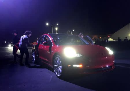 Customer employees receive some of the first Model 3 cars off the Fremont factory's production line during an event at the company's facilities in Fremont, California, U.S., July 28, 2017. REUTERS/Alexandria Sage