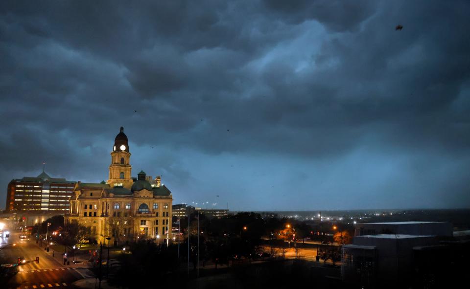 Debris flies through the air as howling winds accompanied by a line of storms approach the old Tarrant County Courthouse in downtown Fort Worth, Texas.