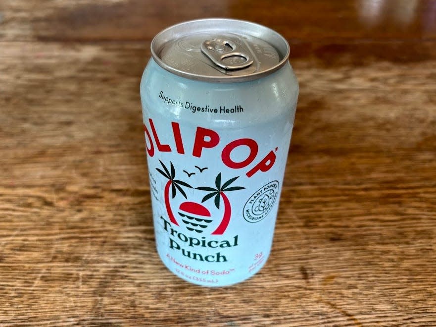 A can of tropical punch Olipop on a wooden table.