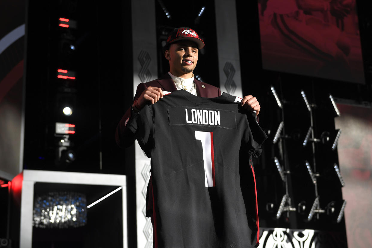 Drake London poses onstage after being selected eighth by the Atlanta Falcons during round one of the 2022 NFL Draft