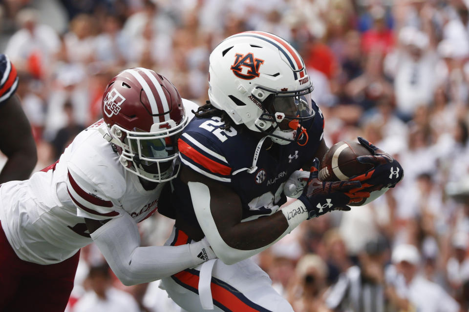 Auburn running back Damari Alston (22) carries the ball in for a touchdown as Massachusetts linebacker Michael Oppong (24) defends during the first half of an NCAA college football game Saturday, Sept. 2, 2023, in Auburn, Ala. (AP Photo/Butch Dill)