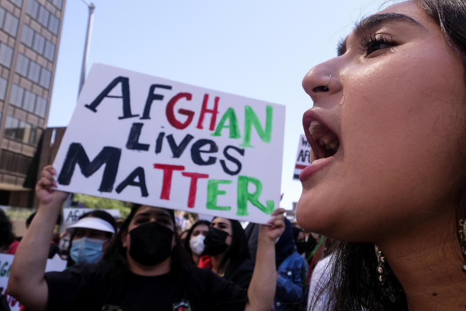 FILE - A protester shouts slogans in a demonstration to call for an "Open Door" policy for Afghanistan evacuees and expedited processing of immigration cases, Aug. 28, 2021, in Los Angeles. More than a year after the Taliban takeover that saw thousands of Afghans rushing to Kabul's international airport amid the chaotic U.S. withdrawal, Afghans at risk who failed to get on evacuation flights say they are still struggling to find safe and legal ways out of the country. (AP Photo/Ringo H.W. Chiu, File)