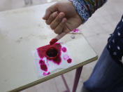 A voter dips her finger in ink during the first day of three-day voting on constitutional amendments in Cairo, Egypt, Saturday, April 20, 2019. Egyptians are voting on constitutional amendments that would allow el-Sissi to stay in power until 2030. (AP Photo/Amr Nabil)