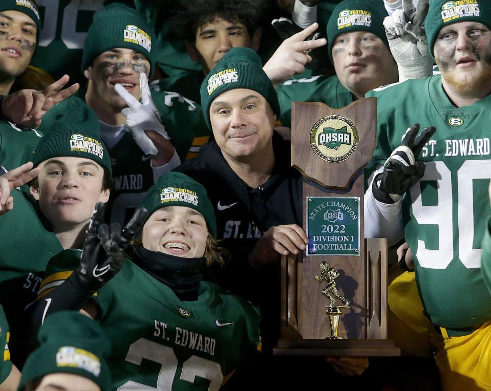 St. Edward Eagles coach Tom Lombardo poses for photos with his team after receiving the Division I state championship trophy after defeating Springfield at Tom Benson Hall of Fame Stadium, Friday, Dec. 2, 2022.