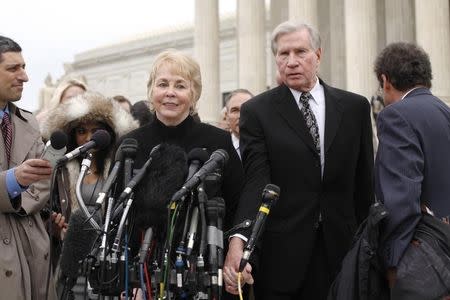 Pamela Hurst and her husband Douglas Hurst, plaintiffs against the U.S. government in the King v. Burwell case, take to the microphones to speak to reporters after arguments at the Supreme Court building in Washington, March 4, 2015. REUTERS/Jonathan Ernst