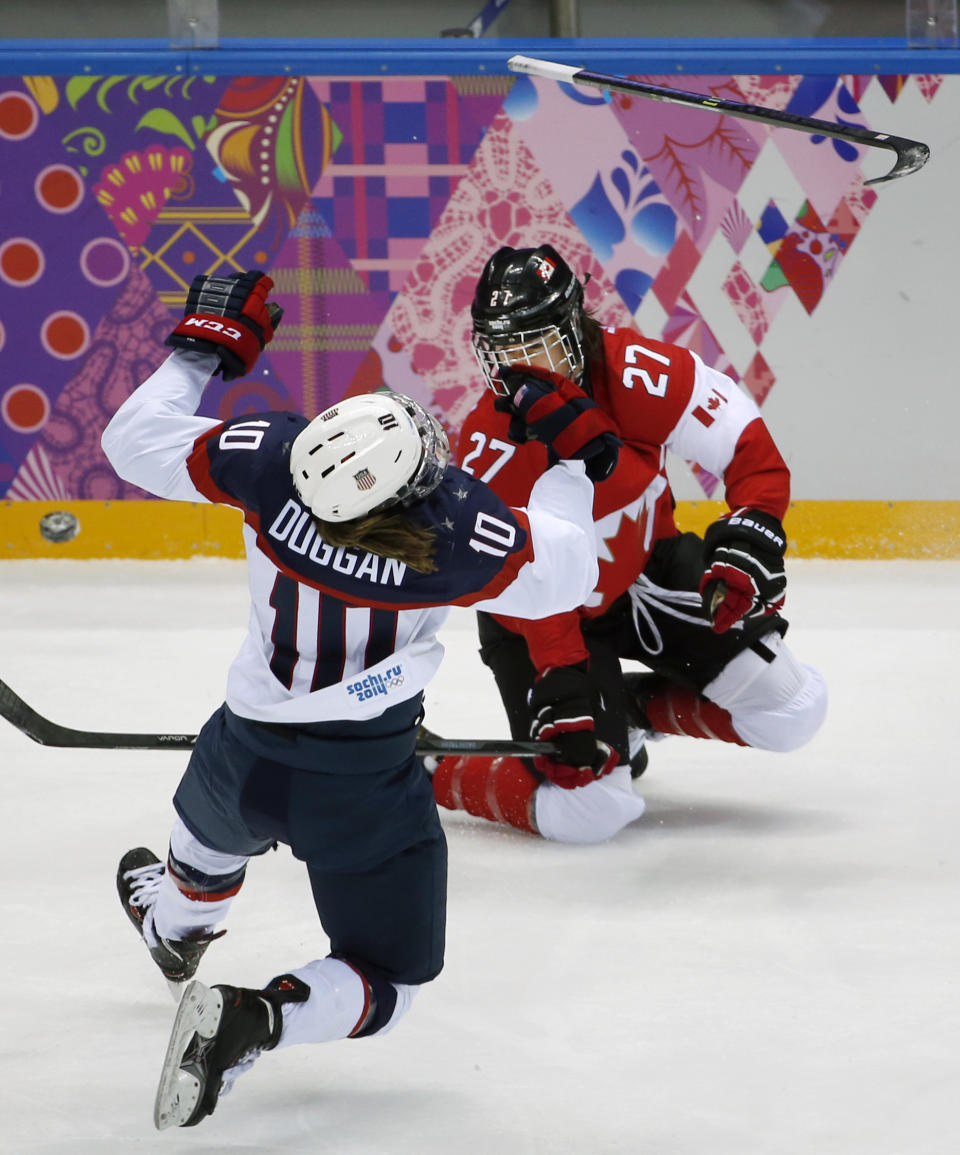 Meghan Duggan of the United States (10) collides with Tara Watchorn of Canada (27) during the first period of the women's gold medal ice hockey game at the 2014 Winter Olympics, Thursday, Feb. 20, 2014, in Sochi, Russia. (AP Photo/Julio Cortez)