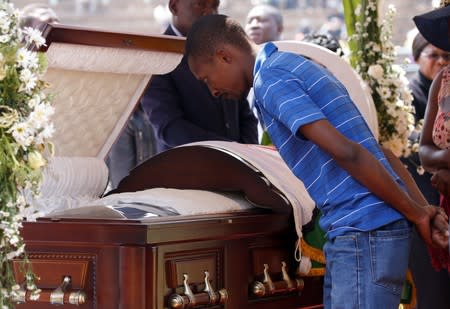 A mourner pays his last respects to Robert Mugabe's body as it lies in state at the at Rufaro stadium