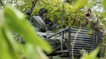 Ukrainian servicemen speak on a T-80 tank that they claimed had been captured from the Russian army, in Bakhmut, Ukraine, Sunday, Oct. 2, 2022. (AP Photo/Inna Varenytsia)