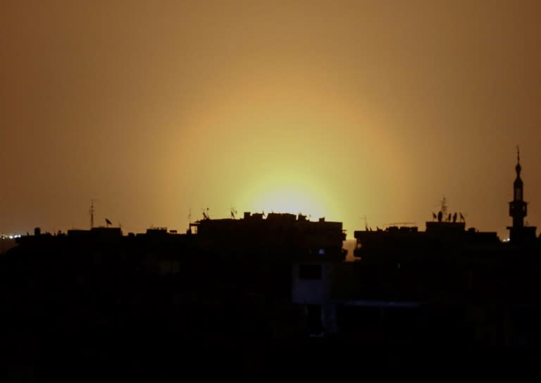 A photo taken from the rebel-held town of Douma shows flames rising in the distance which are believed to be coming from Damascus International Airport following an explosion early in the morning of April 27, 2017