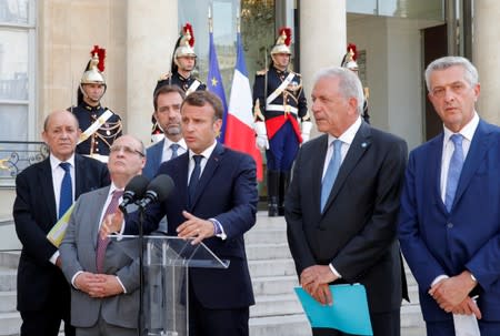 Le Drian, Vitorino, Castaner, Macron, Avramopoulos and Grandi deliver a joint statement at the Elysee Palace in Paris