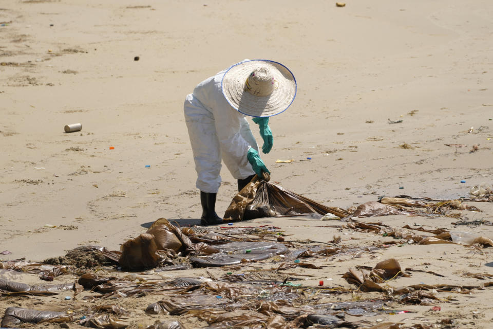 Workers carry out a cleanup operation on Mae Ramphueng Beach after a pipeline oil spill off the coast of Rayong province in eastern Thailand, Sunday, Jan. 30, 2022. The governor of a province in eastern Thailand on Saturday declared a state of emergency after an oil slick washed up on a sand beach, shutting down restaurants and shops in a setback for the pandemic-hit tourism industry. (AP Photo/Sakchai Lalit)