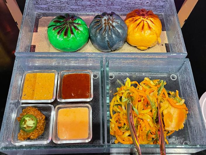 A tray of colorful buns, sauces, and shredded noodles at the Starcruiser