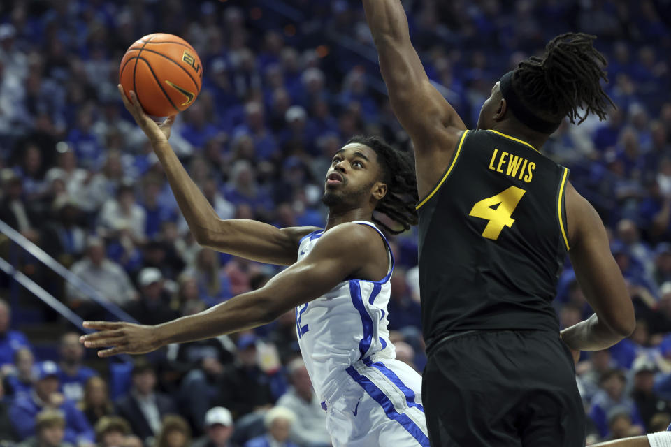 Kentucky's Antonio Reeves (12), left, shoots while pressured by Missouri's Curt Lewis (4) during the first half of an NCAA college basketball game in Lexington, Ky., Tuesday, Jan. 9, 2024. (AP Photo/James Crisp)