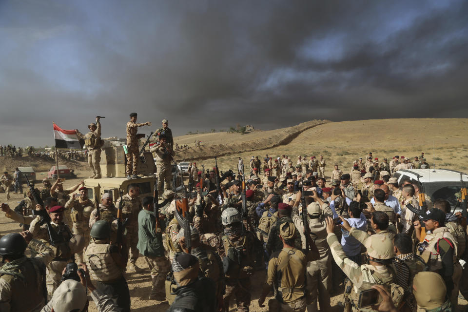 FILE - In this Oct. 20, 2016 file photo, Iraqi army soldiers raise their weapons in celebration after a pre-dawn advance on the nearby town held by the Islamic State group, on the outskirts of Mosul, Iraq. Ten years ago, an uprising in Tunisia opened the way for a wave of popular revolts against authoritarian rulers across the Middle East known as the Arab Spring. For a brief window as leaders fell, it seemed the move toward greater democracy was irreversible. Instead, the region saw its most destructive decade of the modern era. Syria, Yemen, Libya and Iraq have been torn apart by wars, displacement and humanitarian crisis. (AP Photo, File)