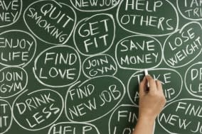 woman hand writing new year's resolutions on the blackboard