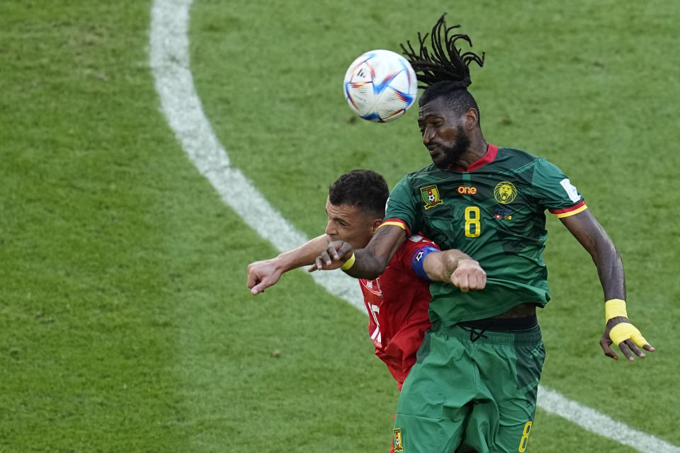 Switzerland's Granit Xhaka jumps for a header with Cameroon's Andre-Frank Zambo Anguissa, right, during the World Cup group G soccer match between Switzerland and Cameroon, at the Al Janoub Stadium in Al Wakrah, Qatar, Thursday, Nov. 24, 2022. (AP Photo/Ebrahim Noroozi)