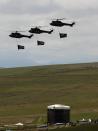 Army helicopters carry South African flags over the burial ground of late former South African President Nelson Mandela during his funeral in Qunu, December 15, 2013 REUTERS/Yannis Behrakis (SOUTH AFRICA - Tags: POLITICS OBITUARY SOCIETY MILITARY)