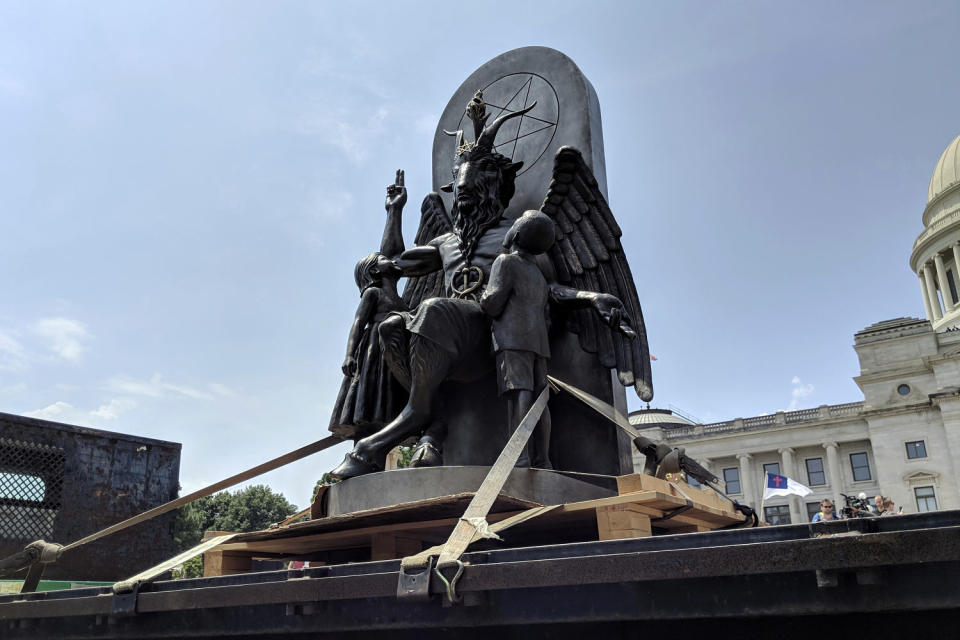 Image: A statue of Baphomet surrounded by children. Baphomet sits on a throne adorned with a pentagram. (Hannah Grabenstein / AP file)