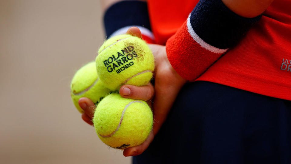 Pictured here, a ball person holds tennis balls during a French Open match.