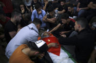 Palestinian mourners gather around the body of Obaida Jawabreh, who was killed in clashes with Israeli forces, during his funeral in the West Bank refugee camp of Al-Arrub, Tuesday, May 18, 2021. (AP Photo/Mahmoud Illean)