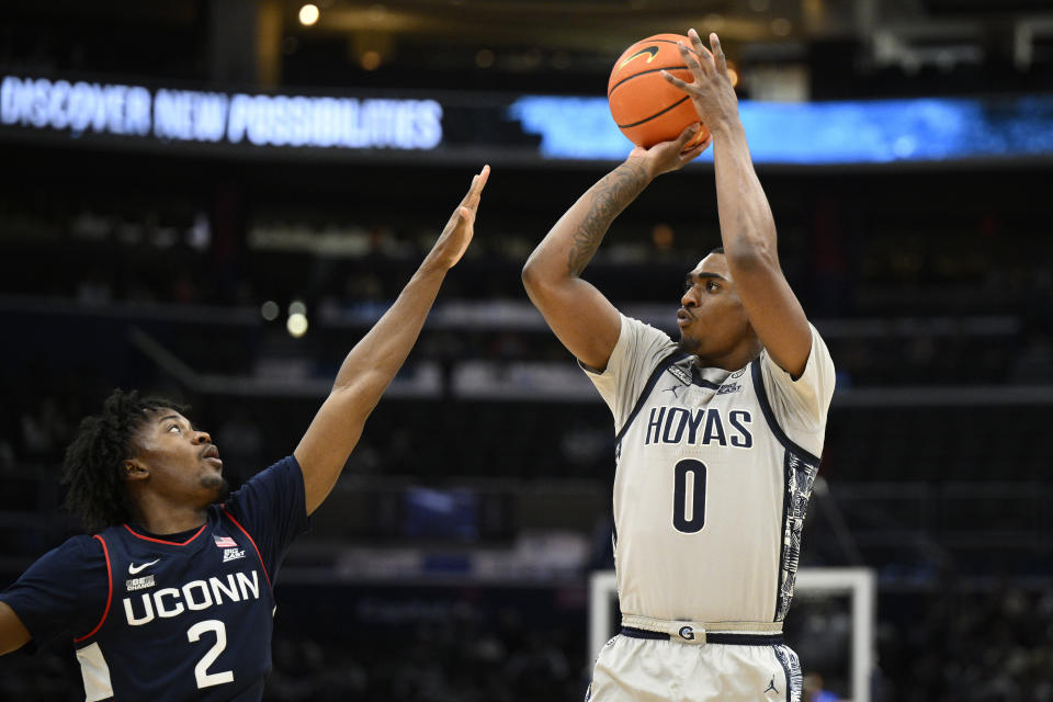 Georgetown guard Brandon Murray (0) shoots against Connecticut guard Tristen Newton (2) during the second half of an NCAA college basketball game, Saturday, Feb. 4, 2023, in Washington. Connecticut won 68-62. (AP Photo/Nick Wass)