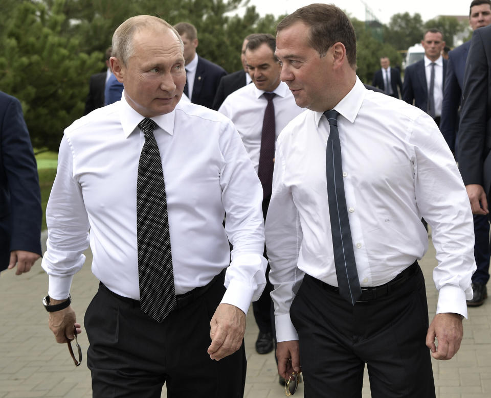 FILE In this file photo taken on Friday, Aug. 16, 2019, Russian President Vladimir Putin, left, and Prime Minister Dmitry Medvedev talk to each other as they visit the VolleyGrad Beach Sports Centre in Anapa, South Russia. Russian President Vladimir Putin prepares to mark his 20th year in power, as the longest-serving leader since Joseph Stalin. (Alexei Nikolsky, Sputnik, Kremlin Pool Photo via AP, File)