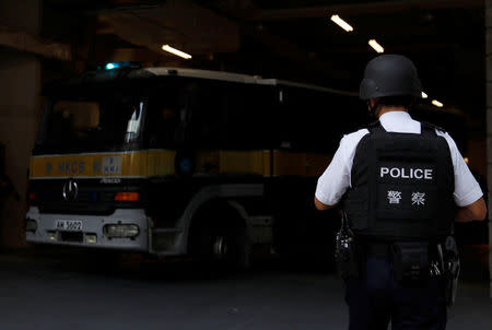 An armed policeman guards the entrance as a prison car carrying British former banker Rurik Jutting leaves High Court in Hong Kong, China November 7, 2016. REUTERS/Tyrone Siu