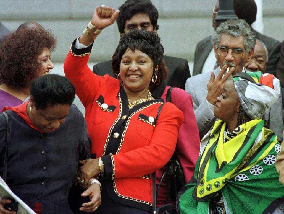 <p>Winnie Mandela dances outside Parliament after the approval of South Africa’s new constitution on May 8, 1996. Despite fears that parties would not reach the required two-thirds consensus, the draft was passed with only 10 votes against it. Others are unidentified. (Photo: Mike Hutchings/pool/AP) </p>
