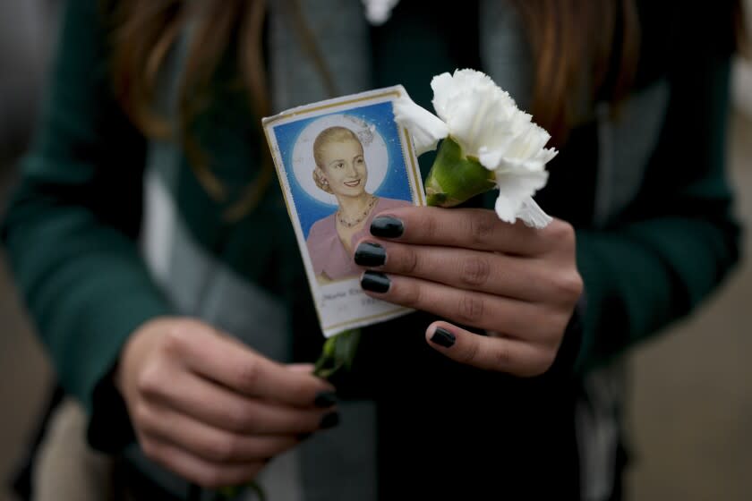 Una mujer sostiene una fotografía de la difunta primera dama de Argentina, María Eva Duarte de Perón, mejor conocida como Evita, mientras espera su turno para visitar la tumba de Evita en Buenos Aires, Argentina, el martes 26 de julio de 2022. Los argentinos conmemoran el 70 aniversario de la muerte de su primera dama más famosa, que murió de cáncer el 26 de julio de 1952 a la edad de 33 años. (AP Foto/Natacha Pisarenko)