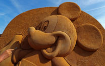 <p>Sand carver Konstantin Kuzyarin from Russia works on a sculpture during the Sand Sculpture Festival “Disney Sand Magic” in Ostend, Belgium June 22, 2017. (Yves Herman/Reuters) </p>