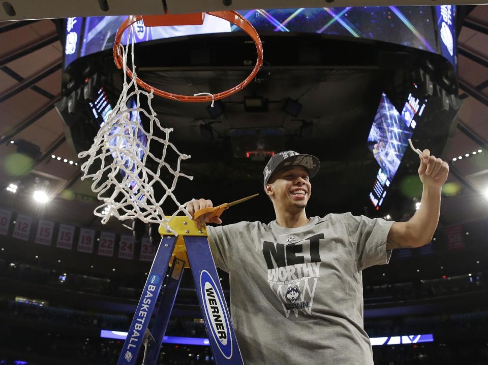 Connecticut's Shabazz Napier smiles after cutting the net after a regional final against Michigan State in the NCAA college basketball tournament Sunday, March 30, 2014, in New York. Connecticut won the game 60-54. (AP Photo/Seth Wenig)