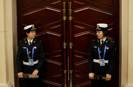 Female soldiers of the People's Liberation Army (PLA) Navy stand at an entrance during a news conference ahead of the 70th anniversary of the founding of Chinese People's Liberation Army Navy, in Qingdao, China, April 20, 2019. REUTERS/Jason Lee
