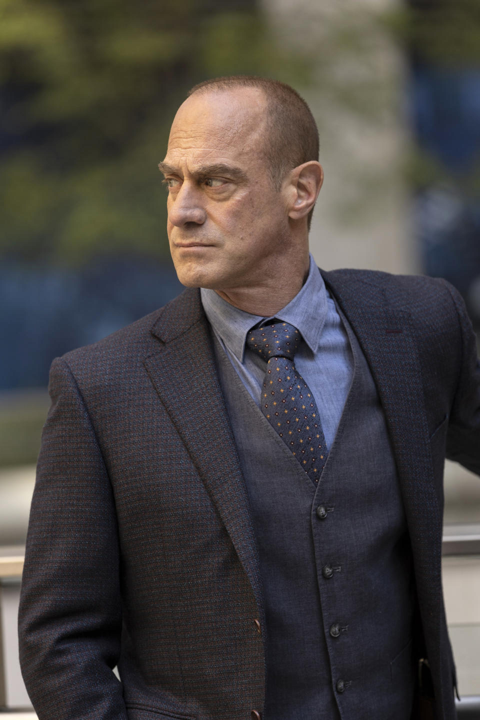 Meloni filming Law & Order Organized Crime in a three-piece suit, looking stern