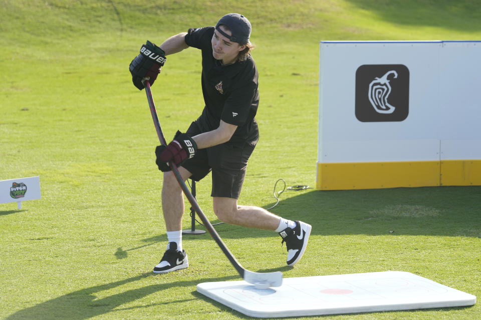 Arizona Coyotes forward Clayton Kellar hits his first shot with a hockey stick during a golf skills competition, Wednesday, Feb. 1, 2023, in Plantation, Fla. The event was part of the NHL All Star weekend. (AP Photo/Marta Lavandier)