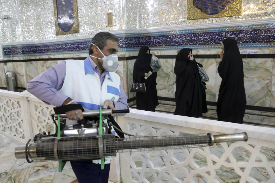 A man disinfects the shrine of the Shiite Saint Imam Abdulazim to help prevent the spread of the new coronavirus in Shahr-e-Ray, south of Tehran, Iran, Saturday, March, 7, 2020. (AP Photo/Ebrahim Noroozi)
