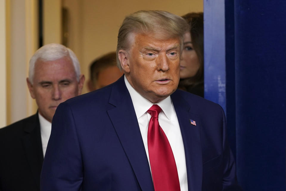 President Donald Trump, followed by Vice President Mike Pence, left, walks into the briefing room at the White House in Washington, Tuesday, Nov. 24, 2020, to make a statement. (AP Photo/Susan Walsh)