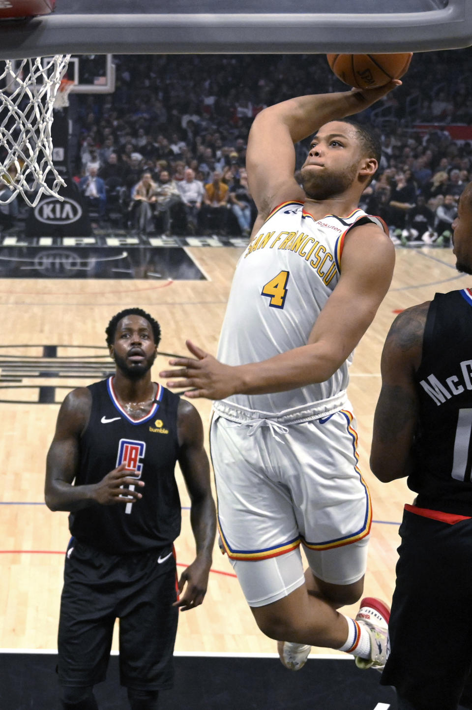 Golden State Warriors forward Omari Spellman, right, goes up for a dunk as Los Angeles Clippers forward JaMychal Green, left, watches during the first half of an NBA basketball game Friday, Jan. 10, 2020, in Los Angeles. (AP Photo/Mark J. Terrill)