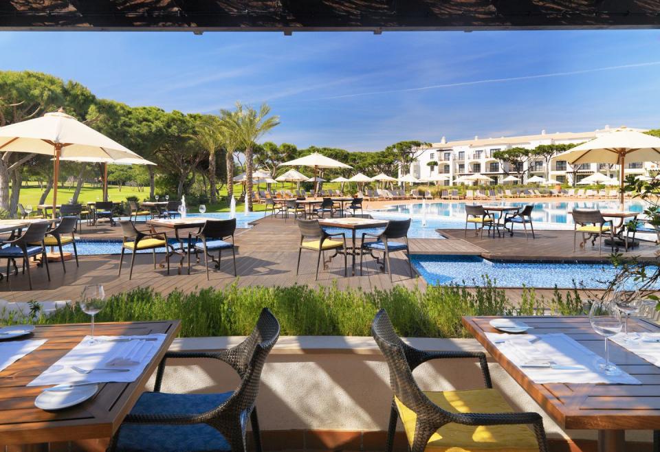 a pool with tables and chairs next to it