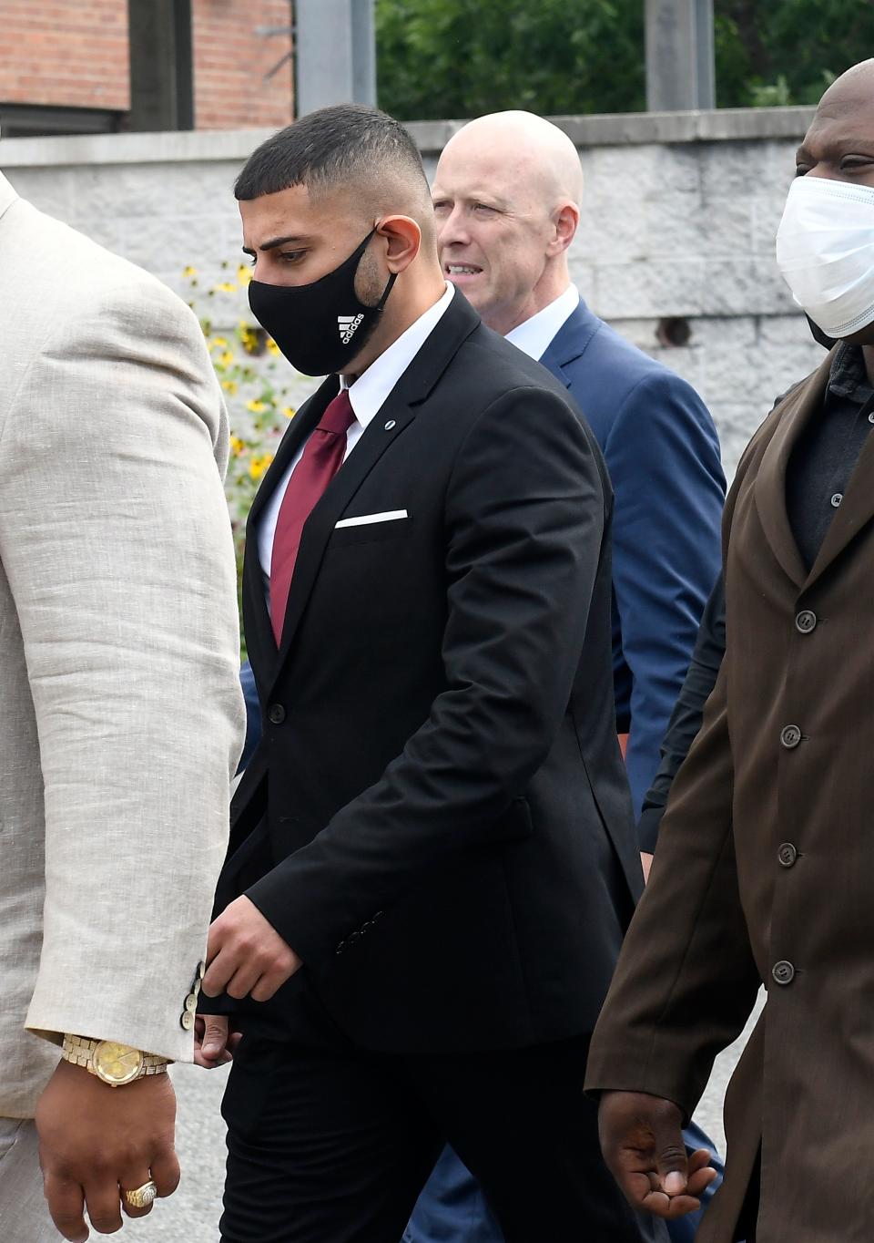 Nauman Hussain, left, who is charged with 20 counts of second degree manslaughter and criminally negligent homicide in the 2018 limousine crash, walks with his attorney Lee Kindlon at the Schoharie High School gymnasium Thursday, Sept. 2, 2021, in Schoharie, N.Y. (AP Photo/Hans Pennink)