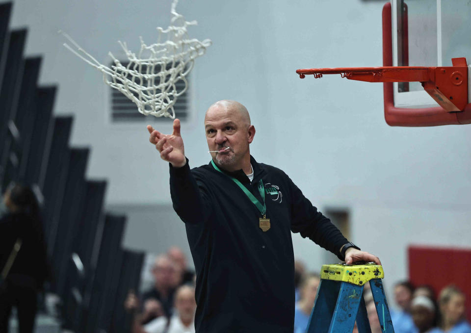 Mason head coach Rob Matula tosses the net from the Comets' district championship win over Centerville Saturday, March 2, 2024.